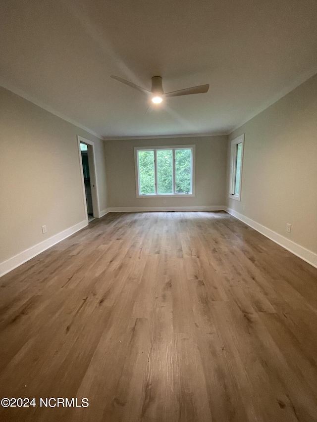 unfurnished room with baseboards, a ceiling fan, and wood finished floors