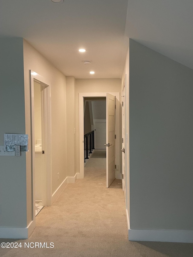 hall with baseboards, recessed lighting, and light carpet