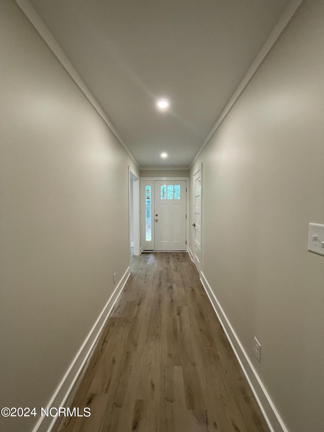 doorway to outside featuring baseboards, ornamental molding, dark wood-type flooring, and recessed lighting