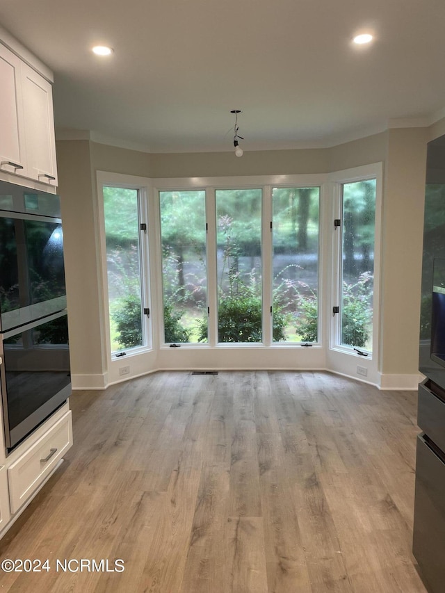 unfurnished living room with crown molding, recessed lighting, baseboards, and light wood-style flooring
