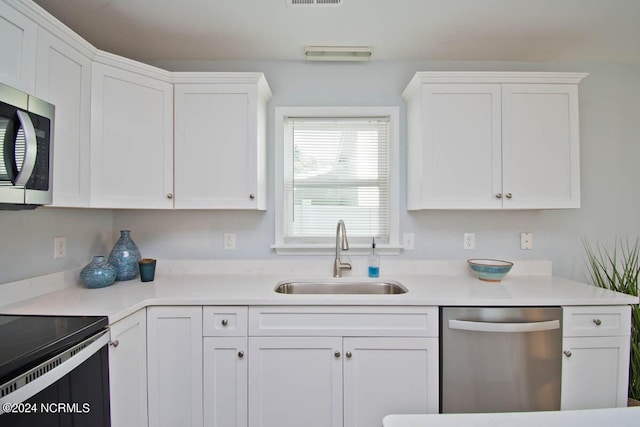 kitchen with sink, white cabinets, and appliances with stainless steel finishes