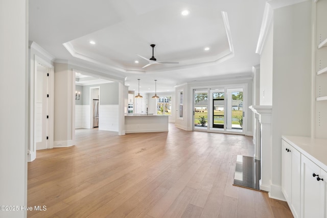 5037 Saltgrass Cv, Leland, NC 28451 - unfurnished living room with a tray ceiling, ceiling fan, ornamental molding, light wood-style flooring, and recessed lighting