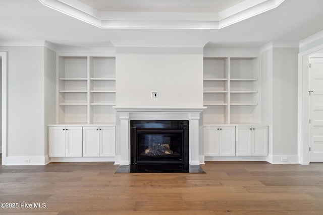 5037 Saltgrass Cv, Leland, NC 28451 - unfurnished living room with wood finished floors, a fireplace with flush hearth, a raised ceiling, and ornamental molding