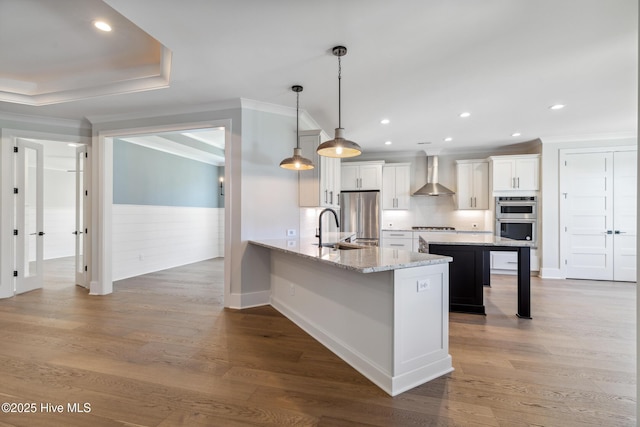 5037 Saltgrass Cv, Leland, NC 28451 - kitchen with wall chimney exhaust hood, appliances with stainless steel finishes, a breakfast bar, a wainscoted wall, and ornamental molding