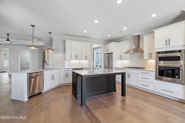 5037 Saltgrass Cv, Leland, NC 28451 - kitchen with wall chimney exhaust hood, appliances with stainless steel finishes, ornamental molding, a peninsula, and a sink