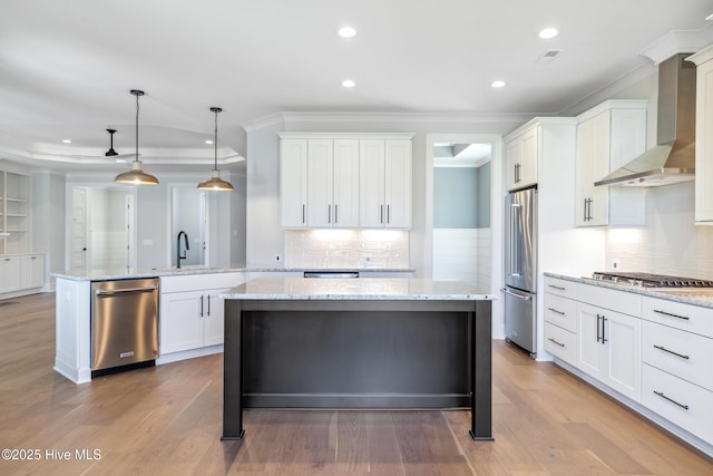 5037 Saltgrass Cv, Leland, NC 28451 - kitchen featuring appliances with stainless steel finishes, wall chimney range hood, ornamental molding, a peninsula, and white cabinets