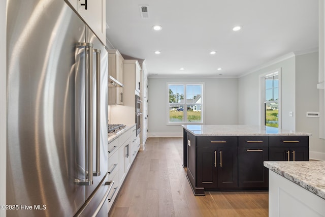 5037 Saltgrass Cv, Leland, NC 28451 - kitchen featuring stainless steel appliances, ornamental molding, white cabinets, recessed lighting, and a kitchen island