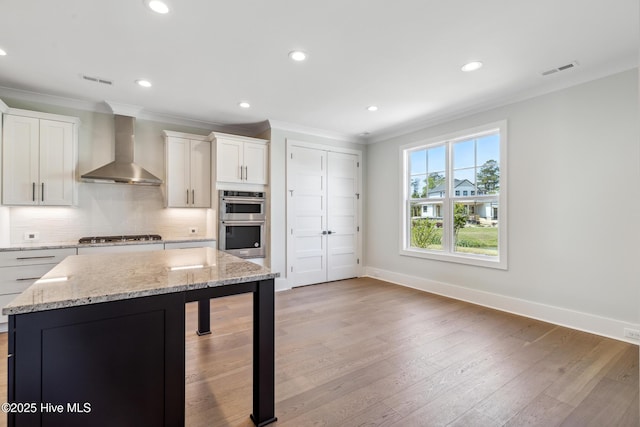 5037 Saltgrass Cv, Leland, NC 28451 - kitchen featuring wall chimney range hood, appliances with stainless steel finishes, ornamental molding, backsplash, and recessed lighting
