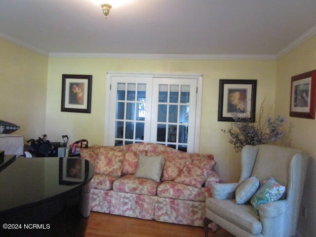 living room with crown molding and wood finished floors