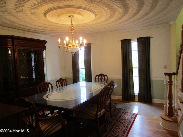 dining area with baseboards, a chandelier, wood finished floors, and ornamental molding