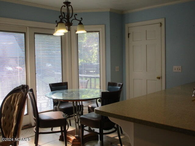 dining area featuring ornamental molding and a chandelier