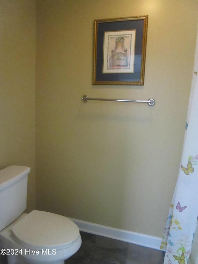 bathroom with baseboards and toilet