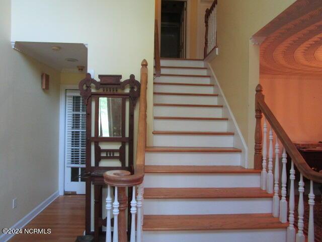 stairway featuring baseboards and wood finished floors