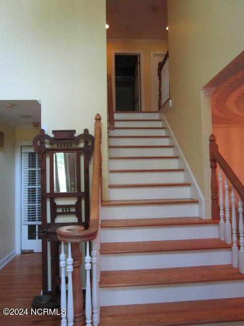 stairway with wood finished floors and baseboards