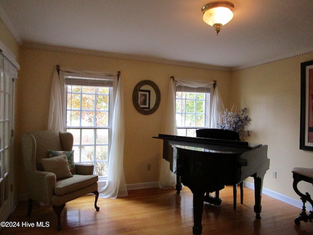 sitting room featuring crown molding, wood finished floors, and baseboards