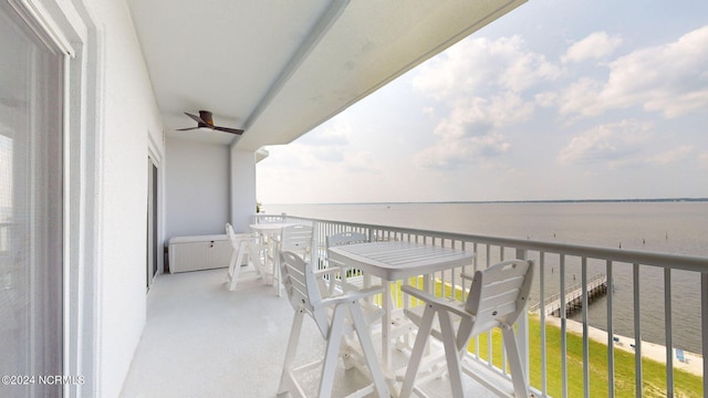 balcony with ceiling fan and a water view