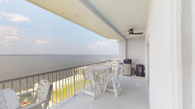 balcony featuring ceiling fan and a water view