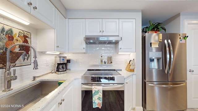 kitchen with wall chimney exhaust hood, decorative backsplash, stainless steel fridge with ice dispenser, stove, and white cabinets