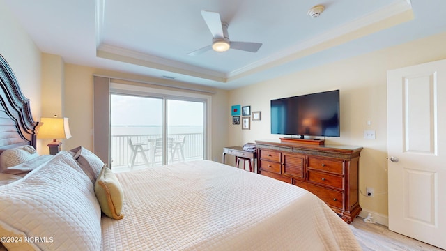 bedroom featuring a tray ceiling, ceiling fan, light hardwood / wood-style floors, and access to outside