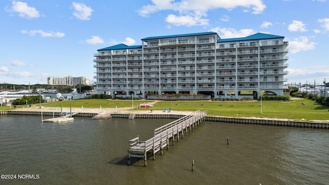 view of dock with a yard and a water view