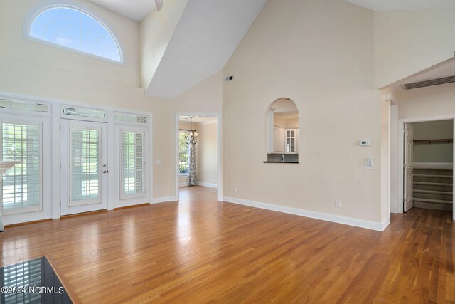 unfurnished living room with baseboards, stairs, visible vents, and wood finished floors