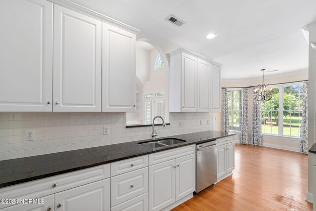 kitchen with a sink, visible vents, white cabinets, dishwasher, and dark stone countertops