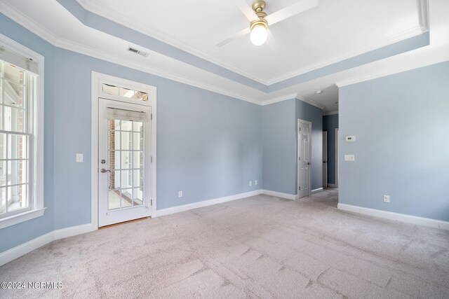 empty room with light carpet, visible vents, and a tray ceiling