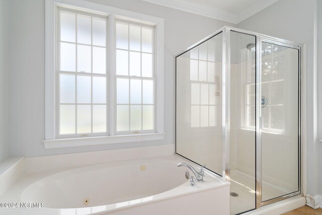 full bathroom featuring ornamental molding, a shower stall, and a bath