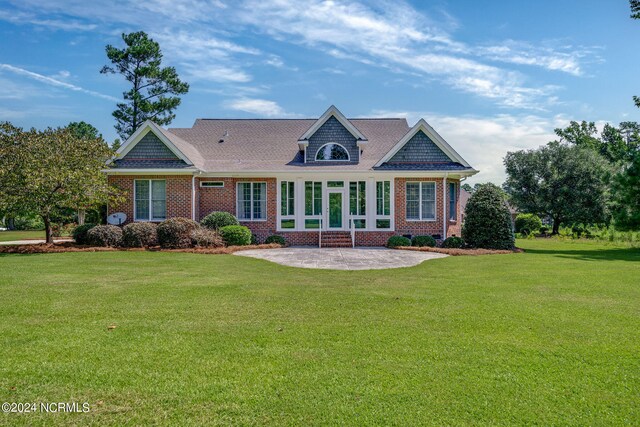 rear view of house with a yard, a patio area, and brick siding