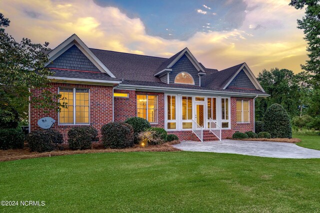 exterior space featuring a patio, brick siding, and a front yard