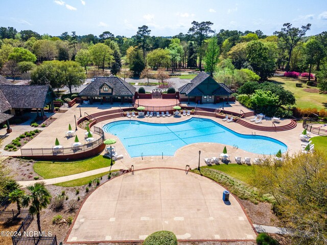 community pool with a patio area and fence