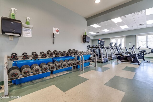 gym featuring a paneled ceiling, visible vents, and tile patterned floors