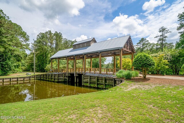 view of dock featuring a water view and a lawn