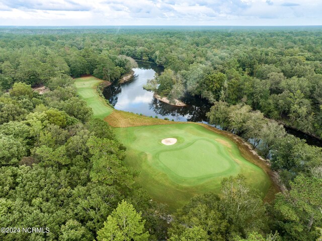 aerial view featuring view of golf course, a water view, and a wooded view