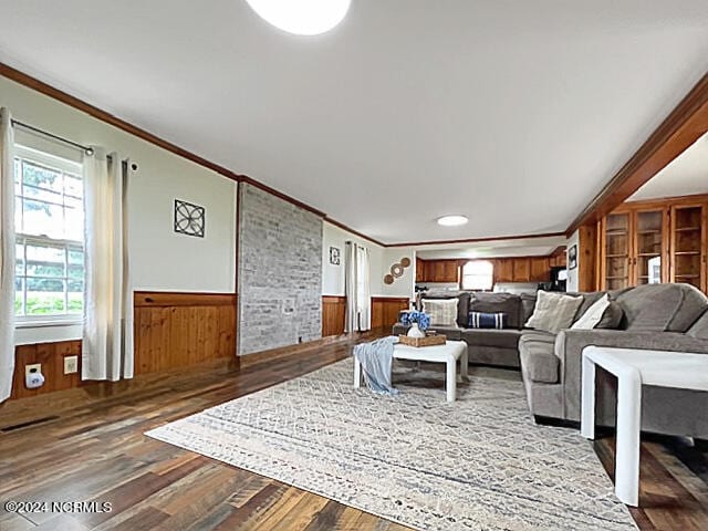 living room featuring crown molding, wooden walls, and hardwood / wood-style floors