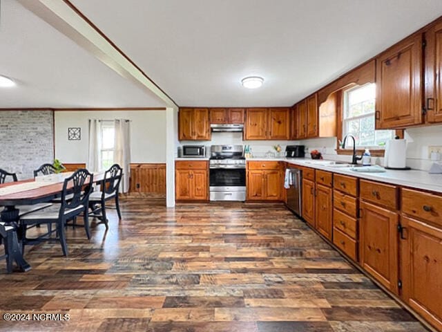 kitchen with crown molding, stainless steel appliances, dark wood-type flooring, and sink