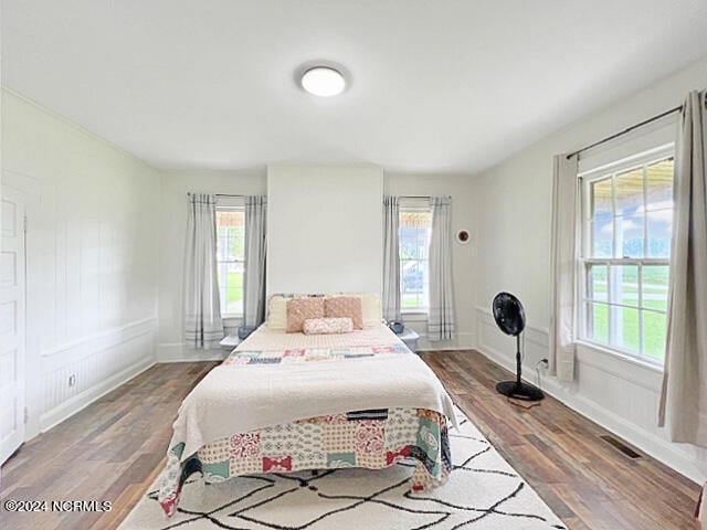 bedroom featuring multiple windows and wood-type flooring