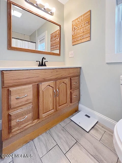 bathroom with toilet, hardwood / wood-style flooring, vanity, and a shower with shower curtain