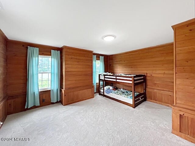 bedroom with carpet flooring and wood walls