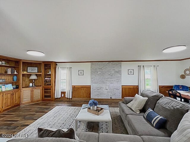 living room featuring crown molding, wooden walls, and dark hardwood / wood-style flooring