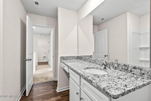 full bath with wood finished floors, visible vents, vanity, baseboards, and a spacious closet