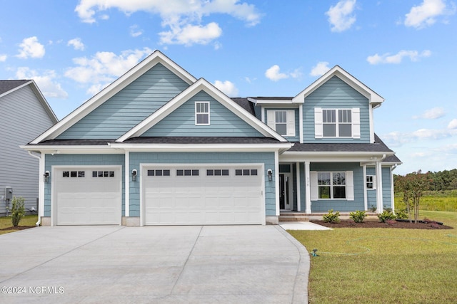 view of front of house with roof with shingles, concrete driveway, covered porch, an attached garage, and a front yard