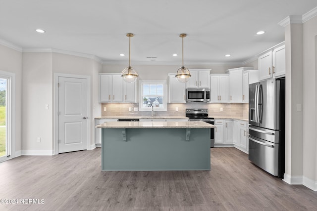 kitchen featuring stainless steel appliances, decorative backsplash, plenty of natural light, and light hardwood / wood-style flooring