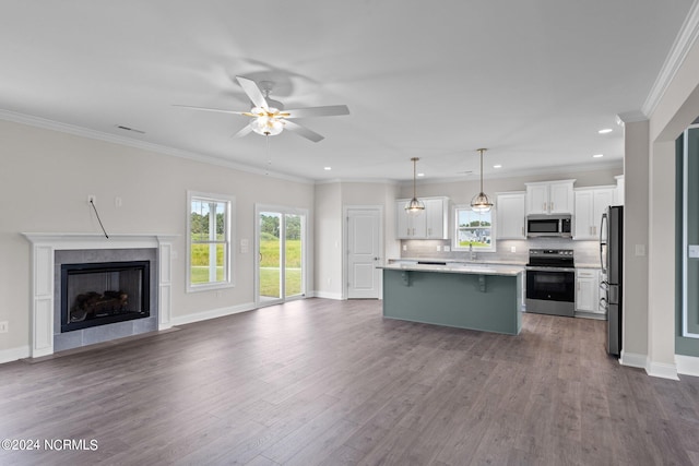 kitchen featuring a kitchen island, hanging light fixtures, wood-type flooring, white cabinets, and stainless steel appliances