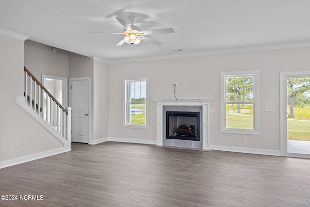 unfurnished living room featuring a fireplace, ceiling fan, ornamental molding, and wood-type flooring