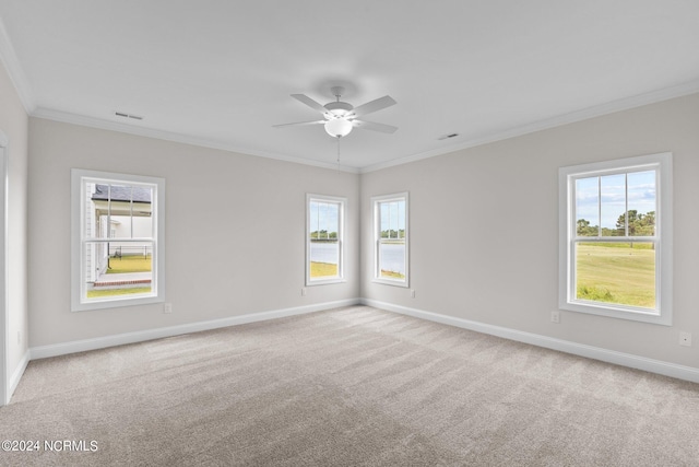 unfurnished room featuring a wealth of natural light, ceiling fan, crown molding, and light carpet