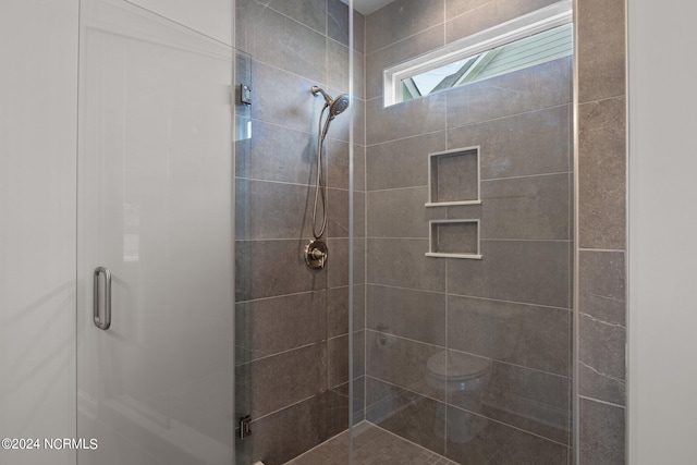 bathroom with a shower with door