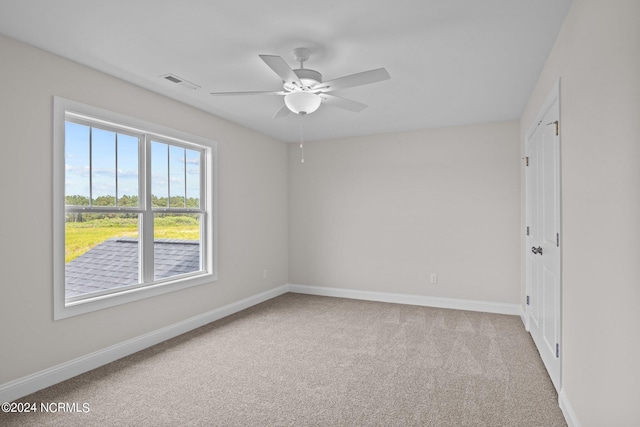 carpeted spare room featuring ceiling fan