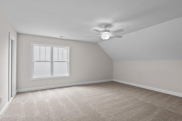 additional living space with ceiling fan, lofted ceiling, and light colored carpet