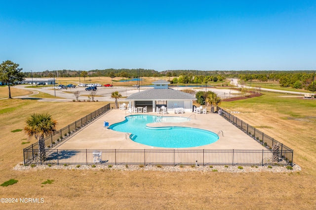 view of pool with a lawn and a patio